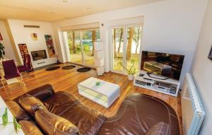 sala de estar con sofá de cuero y TV de pantalla plana en Villa Fortuna, en Bakarac