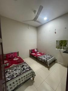 two beds in a room with a ceiling at Irdina Homestay Beserah, Kuantan in Kuantan