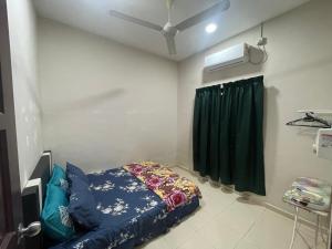 a bedroom with a bed and a green curtain at Irdina Homestay Beserah, Kuantan in Kuantan