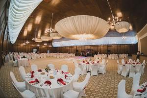 un gran salón de banquetes con mesas blancas y sillas blancas en Hotel Posada, en Râmnicu Vâlcea