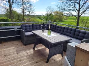 a patio with a table and couch on a deck at Ferienhaus Wind in Struckum