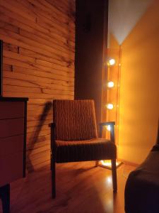 a chair sitting in a room with a wall at Zaļais namiņš in Ventspils +17 photos