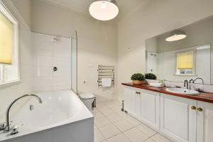 ein Badezimmer mit einer Badewanne, einem WC und einem Waschbecken in der Unterkunft Blackwood Tree Cottage Heritage Listed Evandale in Evandale