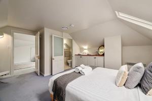 1 dormitorio con 1 cama blanca grande y baño en Blackwood Tree Cottage Heritage Listed Evandale, en Evandale
