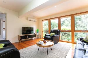 a living room with two couches and a coffee table at East Launceston with Views and Parking in Kings Park