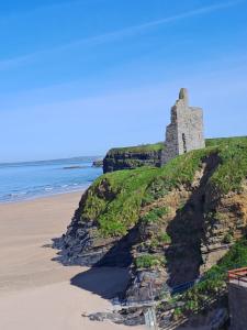 an old castle on a hill next to the beach at 18 Ballybunion Holiday Cottages in Ballybunion