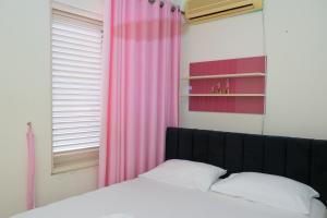 a bedroom with a bed and a pink curtain at Albjona Guesthouse 1 in Tirana