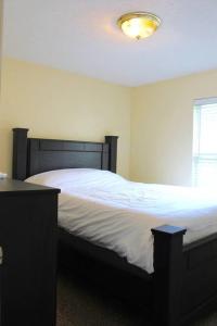 1 dormitorio con 1 cama grande con sábanas blancas en 20 minutes to Downtown Nashville w/ Fenced in Yard, en Goodlettsville