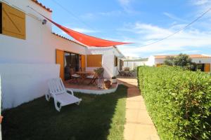 a white house with a chair and a table at Casa Mar in Burgau