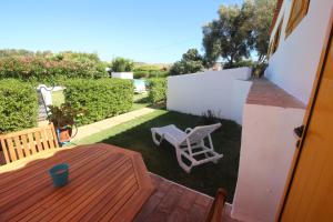 einen kleinen Garten mit einem Holztisch und einem Stuhl in der Unterkunft Casa Mar in Burgau