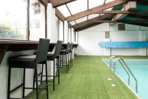 a row of chairs next to a swimming pool at Dual Living with Indoor Pool, Parking and Sauna! in Kings Meadows