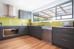 a kitchen with gray cabinets and a large window at Renovated Delight in Invermay in Invermay