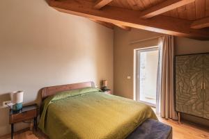 um quarto com uma cama e uma grande janela em Le Talee Agriturismo di Charme em Lioni