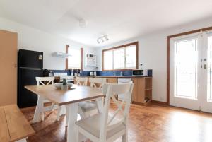 Una cocina y un comedor con mesa y sillas. en Charming Little Home Close To The City w Parking And Wifi, en Kings Park