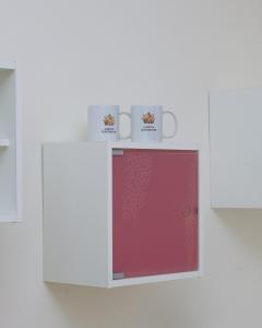 two mugs on top of a white cabinet at Albjona Guesthouse 1 in Tirana