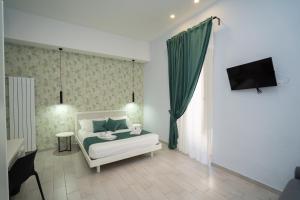 a bedroom with a bed and a television in it at Mida's Boutique Rooms in Naples