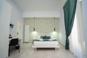 a bedroom with a white bed and a desk at Mida's Boutique Rooms in Naples