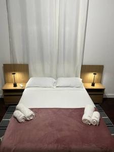 リオデジャネイロにあるCasa Aconchegante-Rio de janeiroのベッドルーム(白い大型ベッド、ランプ2つ付)