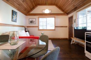 sala de estar con mesa de cristal y TV en Station Cottage, en Kings Park