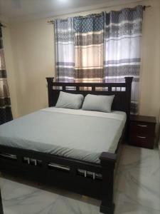 ein Schlafzimmer mit einem Bett in einem Zimmer in der Unterkunft Ana Rooms in Tema