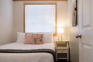Dormitorio pequeño con cama y ventana en Station Cottage, en Kings Park