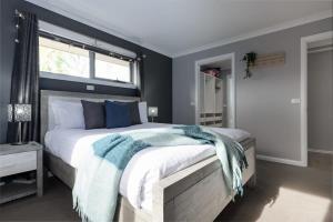 Un dormitorio con una cama grande con una manta azul. en Devonport Delight Close To Ferry Terminal Dog Friendly "Happy Tails", en Devonport