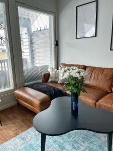 uma sala de estar com um sofá e uma mesa de centro em Modern & Stylish 2BR Apartment with Sauna, Terrace and Free Private Parking em Lahti
