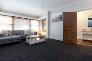 un salon avec un canapé et une table dans l'établissement Classic Cottage: Near CBD Hospital & Parking, à Kings Park