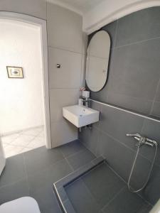 y baño con lavabo y espejo. en Villa Danai, en Toroni