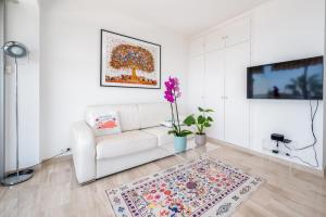 a white living room with a white couch and a rug at Magnifique vue mer panoramique in Vallauris