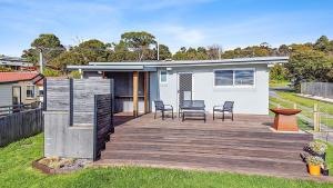 una casa con una terraza de madera con sillas en Sea Breeze Escape en Bridport