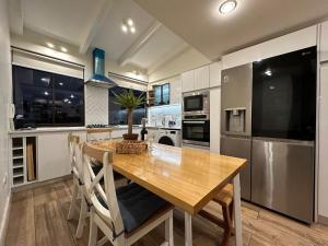 a kitchen with a wooden table and a kitchen with appliances at Moderno, iluminado y céntrico, Valparaíso in Valparaíso