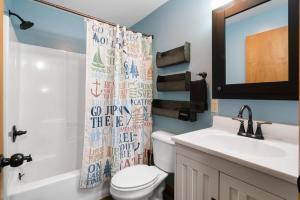 uma casa de banho com um WC, um lavatório e um espelho. em 2 Lakeside Apartment Units in One at Fife Lake Lodge em Fife Lake