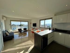 een keuken en woonkamer met een bank en een tafel bij A013-Apt vue mer avec piscine et terrasse in Cannes