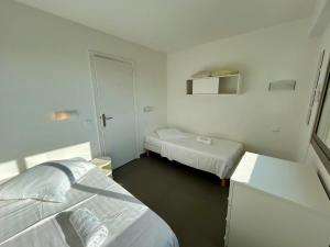 een witte kamer met twee bedden en een kleine kamer met twee bedden bij A013-Apt vue mer avec piscine et terrasse in Cannes +17 foto's