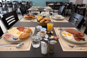 - une table avec des assiettes de produits pour le petit-déjeuner et des boissons dans l'établissement Rooms Rebolj, à Osijek