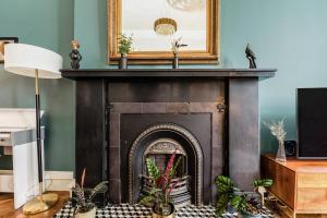a fireplace in a living room with a picture above it at Luxurious Park District Duplex Apartment in Glasgow