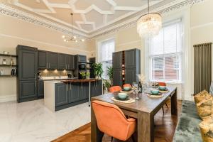a kitchen with a wooden table and a dining room at Luxurious Park District Duplex Apartment in Glasgow