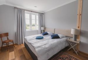 um quarto com uma cama com almofadas azuis e uma janela em Willa Bizorenda em Małogoszcz