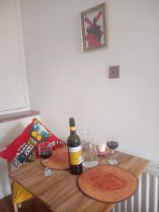 uma mesa com uma garrafa de vinho e dois copos em Thorntree Street Edinburgh em Edimburgo