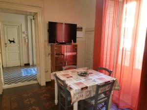 een eetkamer met een tafel en een tv bij Gatti al Borgo in Catania
