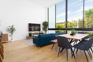 a living room with a blue couch and a table at Bright and Trendy 2-story Bankers Hill Condo in San Diego