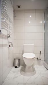 a white bathroom with a toilet and a shower at Guest House Perlyna in Verkhovyna