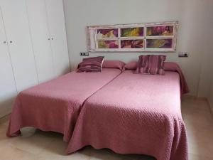 a bedroom with a bed with a pink blanket at La Casa del Arte in Cádiz
