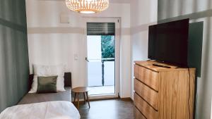 a bedroom with a bed and a television on a dresser at DoreyHome P2 - modernes zentrales Apartment -2-4 Personen - Parkplatz in Passau