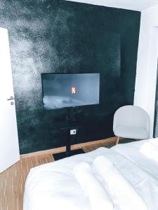 1 dormitorio con 1 cama y TV de pantalla plana en DoreyHome P2 - modernes zentrales Apartment -2-4 Personen - Parkplatz, en Passau