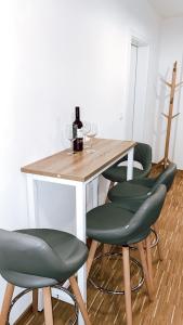 un tavolo con quattro sedie verdi e bicchieri da vino di DoreyHome P2 - modernes zentrales Apartment -2-4 Personen - Parkplatz a Passavia