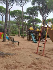 a park with a playground with a slide and swings at Sardegna Calaverde Villetta in Forte Village