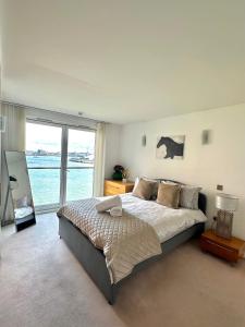 Luxury apartment in Canary Wharf في لندن: غرفة نوم بسرير كبير ونافذة كبيرة
