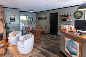 a living room with white chairs and a kitchen at Townsend River Breeze Inn in Townsend